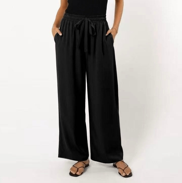 Person wearing black wide-leg pants on a white background