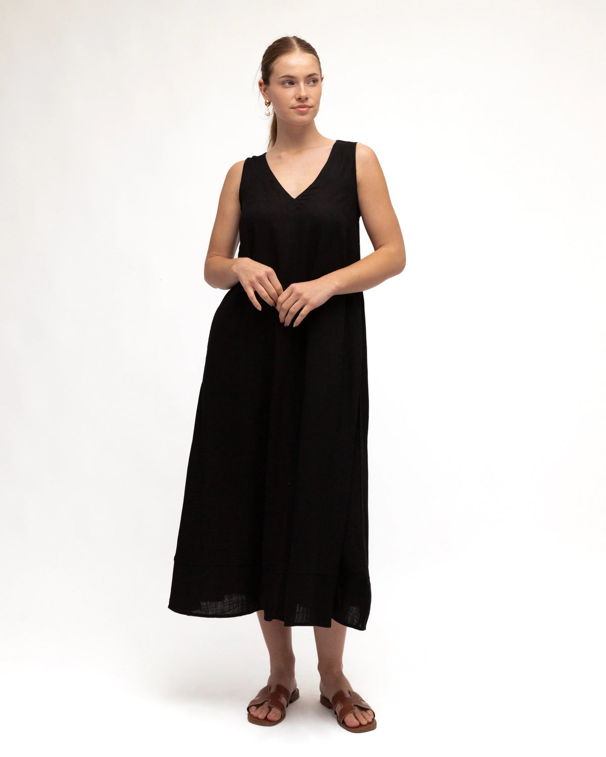 Woman wearing a black sleeveless dress on a white background